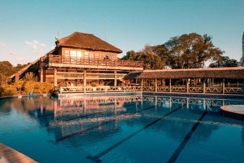 a large wooden building with a large swimming pool at Vila Ventura Ecoresort in Viamão