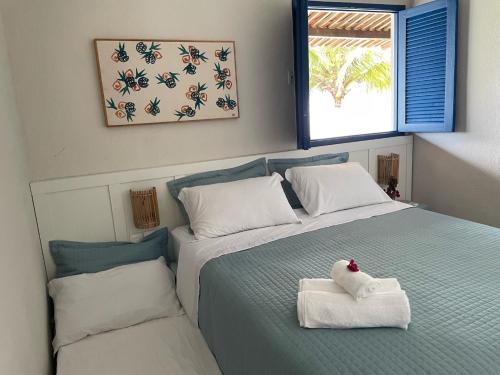 a bedroom with a bed with two towels on it at Casa beira mar, 4 quartos - Sanzé - Maragogi/AL in São José da Coroa Grande