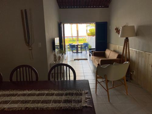 ein Wohnzimmer mit einem Sofa, einem Tisch und Stühlen in der Unterkunft Casa beira mar, 4 quartos - Sanzé - Maragogi/AL in São José da Coroa Grande