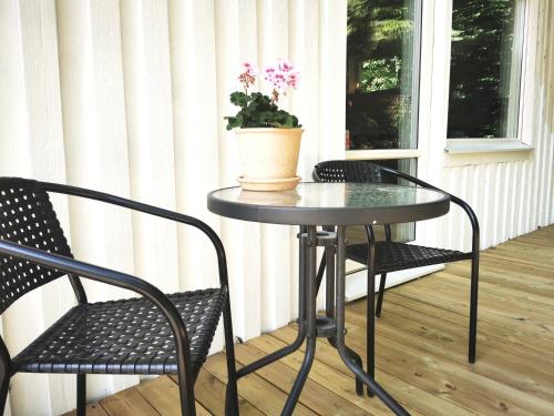 a table and two chairs and a potted plant on a porch at Landvetter Apartment in Landvetter