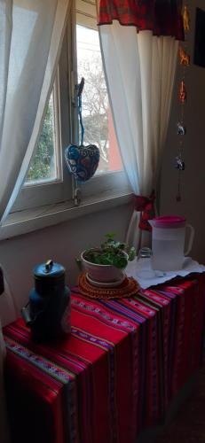 Casa con vista a la salida del sol في لا كومبر: طاولة مع قماش الطاولة الحمراء والنافذة