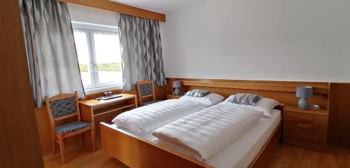 a bedroom with two beds and a window at Garni Hauenstein in Siusi