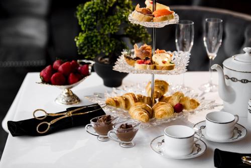 een tafel met een dienblad met gebak en kopjes koffie bij Park Hotel Sankt Peterburg in Plovdiv