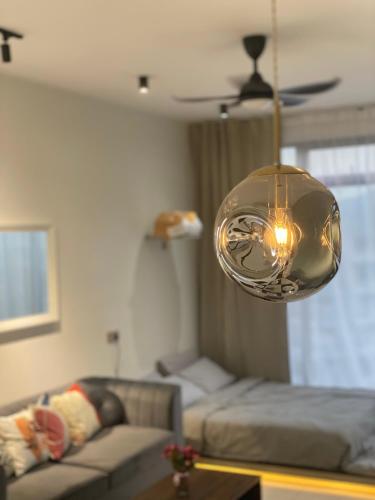 a living room with a couch and a light fixture at Beacon Executive Suite by stayCATion Homestay in George Town