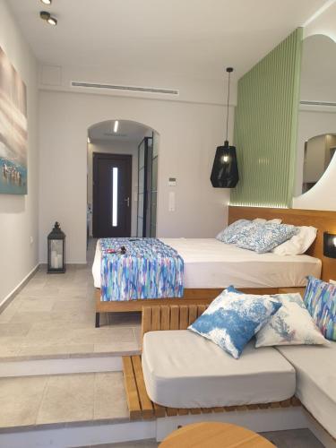 a room with three beds and a couch in it at Vista Al Mare Luxury Apartments in Gialova