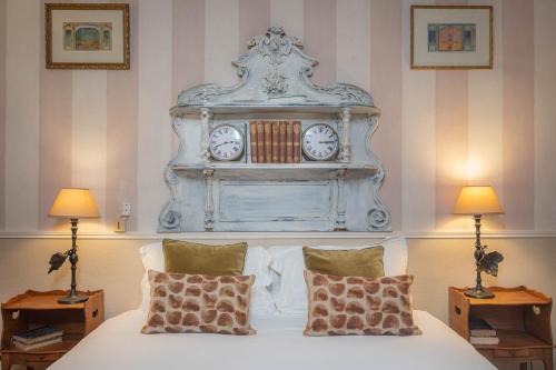 een slaapkamer met een bed met een klok erboven bij Hôtel de l'Avre in Parijs