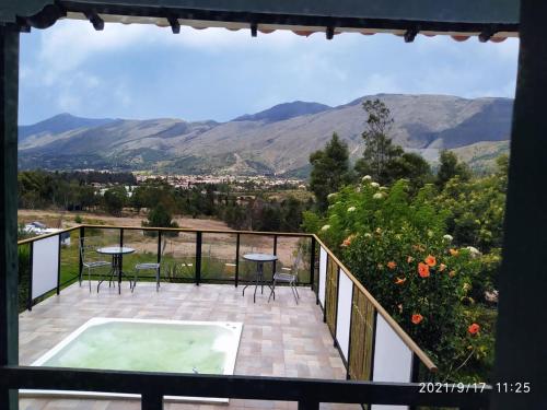 a balcony with a hot tub and a view of mountains at CASA VILLA LUGUIANGA Villa de Leyva in Villa de Leyva