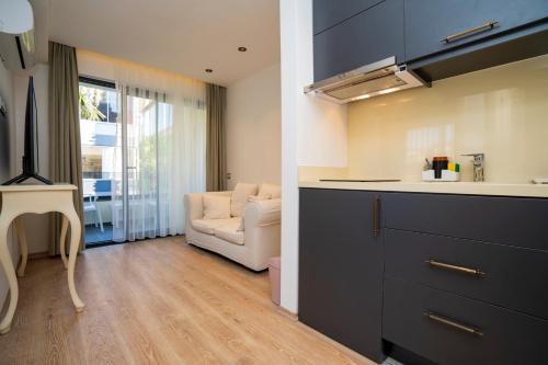 een keuken en een woonkamer met een bank en een tafel bij Channel Suites in Fethiye