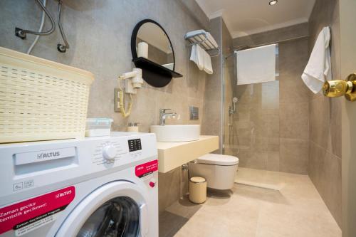 a washing machine in a bathroom with a sink at Channel Suites in Fethiye