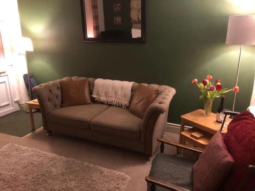 a living room with a couch and a table at Rose Cottage in Wigton