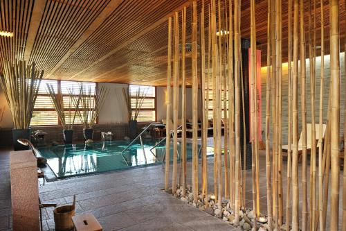 a room with a swimming pool and bamboo walls at Hotel Balnea Superior - Terme Krka in Dolenjske Toplice
