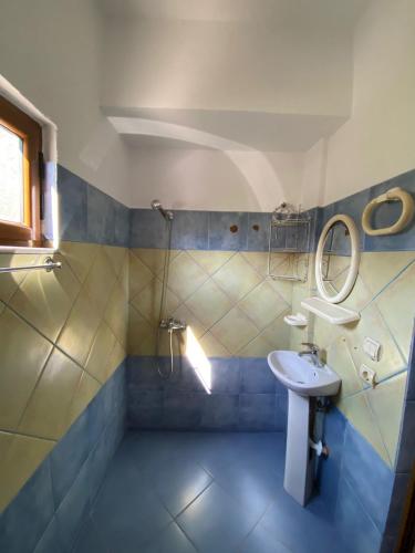 a bathroom with a sink and a toilet and a mirror at Vila Tani in Ksamil