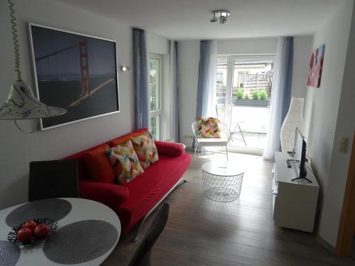 ein Wohnzimmer mit einem roten Sofa und einem Tisch in der Unterkunft Ferienwohnung im Naturpark Rhein-Westerwald in Rengsdorf