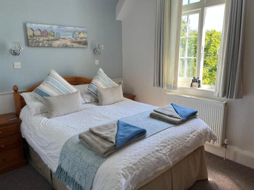 a bedroom with a bed with blue towels on it at Bedford Lodge in Shanklin