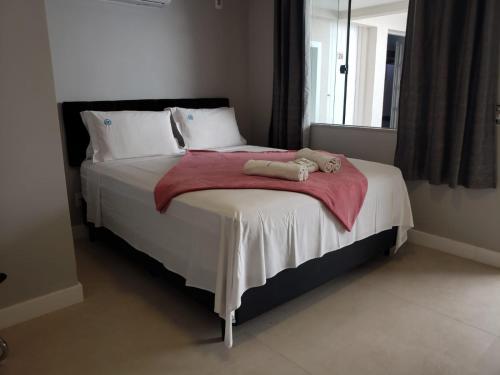 a bedroom with a large bed with a red blanket at Deck de Búzios in Búzios