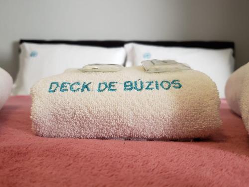 a bed with a pillow with the words back de bubbles on it at Deck de Búzios in Búzios