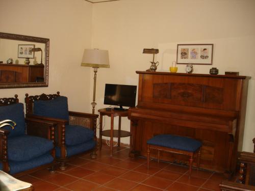 a living room with a piano and two chairs at MAS GUILLO in San Quintín de Mediona
