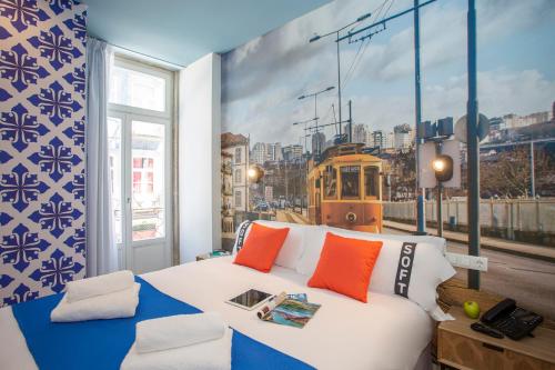 a bedroom with a bed and a mural of a streetcar at Casual Raízes Porto in Porto
