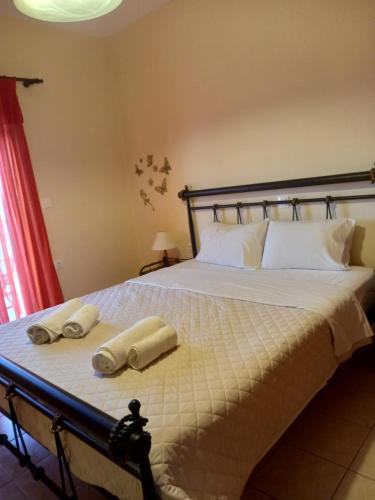 a bedroom with a bed with two towels on it at Flisvos Apartments in Megalochori