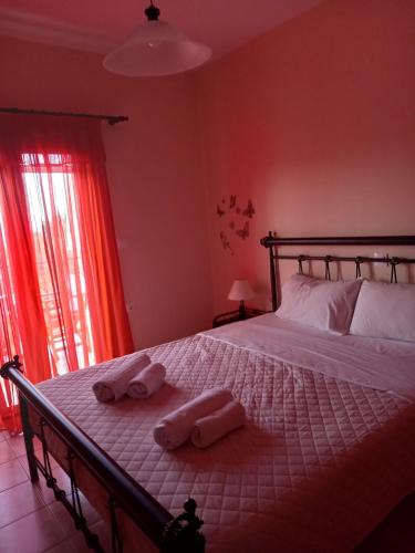 a bedroom with a bed with two towels on it at Flisvos Apartments in Megalochori