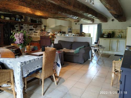 un salon avec une table et un canapé dans l'établissement Au Chat Perché, à Aix-la-Fayette