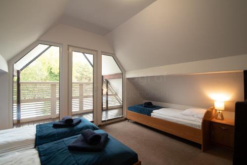 1 dormitorio con 2 camas y balcón en Małe Morze, en Chałupy