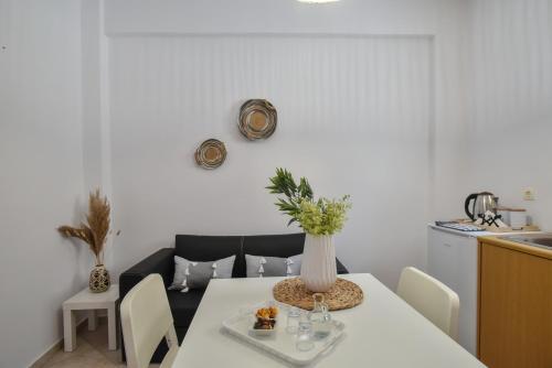 un comedor con una mesa con un jarrón. en Eva Studios & Apartments, en Agia Pelagia