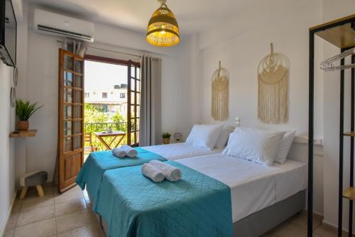 1 dormitorio con 1 cama con toallas en Eva Studios & Apartments, en Agia Pelagia
