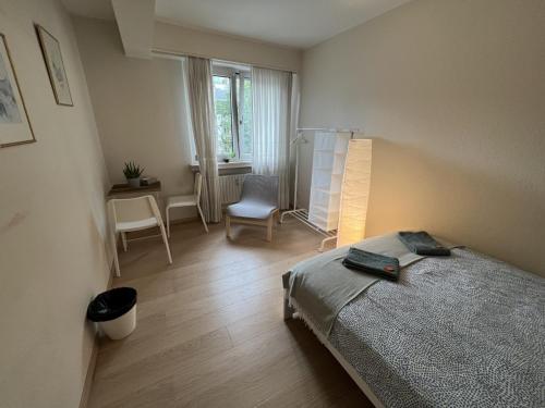 a bedroom with a bed and a chair and a window at rooms train station in Luxembourg