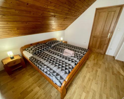 a bedroom with a bed and a wooden ceiling at Margaret Apartment in Balatonkeresztúr