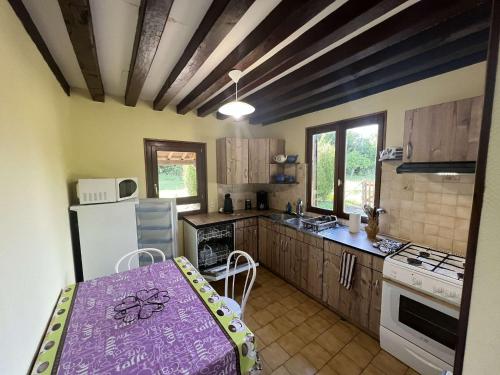 La cuisine est équipée d'une table, d'un réfrigérateur et d'une cuisinière. dans l'établissement Gîte Normand à 10mn d'Honfleur, à Genneville