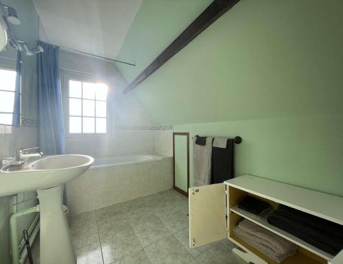 W łazience znajduje się umywalka i wanna. w obiekcie Gîte Normand à 10mn d'Honfleur w mieście Genneville