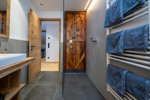 a bathroom with a sink and a wooden door at Ladinser Hof Western Suite in Castelrotto