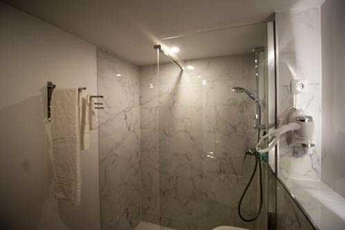 a bathroom with a shower with a glass door at Hotel RBX - Roubaix Centre in Roubaix