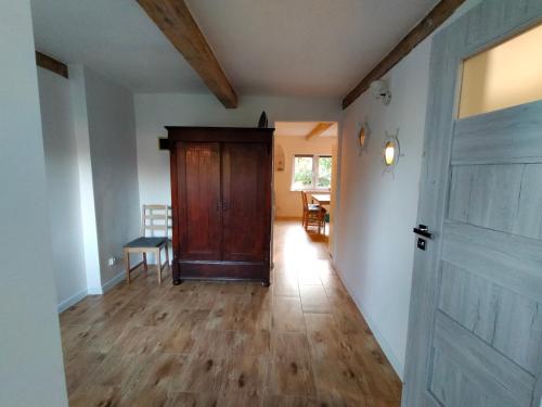 an empty hallway with a wooden door and a table at Michówka in Nickelswalde