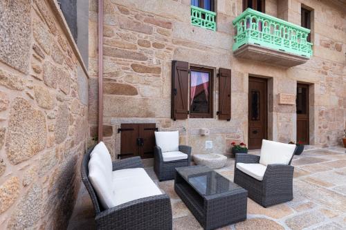 a patio with chairs and tables and a balcony at Casa de Miranda in Ézaro
