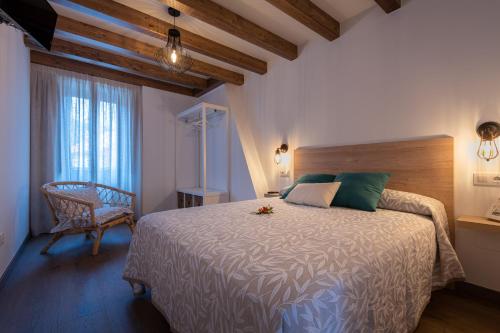 Casa de Miranda في إزارو: غرفة نوم بسرير وكرسي ونافذة
