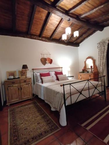 a bedroom with a bed and a wooden ceiling at Gerês - Refúgio das Laranjeiras in Geres