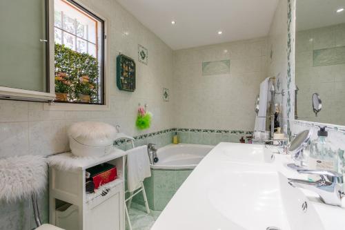 une salle de bain avec un lavabo et une baignoire dans l'établissement Villa Escalinada VI4310 By Riviera Holiday Homes, à Nice