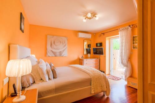- une chambre avec des murs orange et un grand lit dans l'établissement Villa Escalinada VI4310 By Riviera Holiday Homes, à Nice