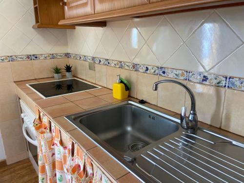 una cocina con fregadero y encimeras de acero inoxidable en Casa Los Palmeros Perdomo en Alojera