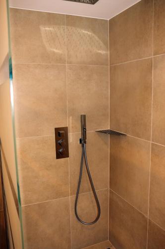 a shower with a hose in a tiled bathroom at Harzhaus Sonnenschein in Wernigerode