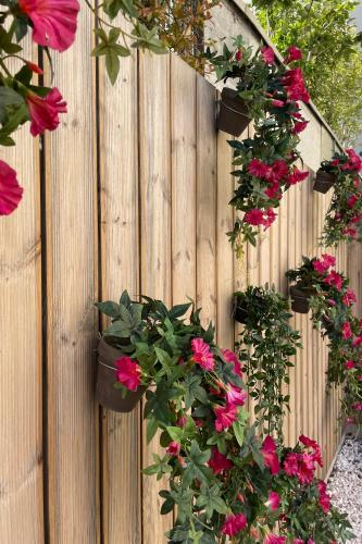 a wooden fence with flowers in flowerpots on it at Casual Raízes Porto in Porto