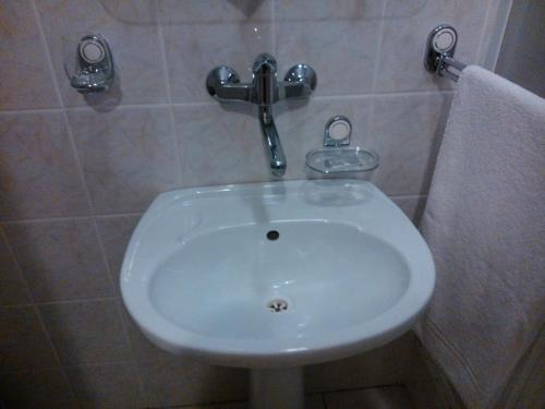a white sink in a bathroom with a towel at Hostel Refleks in Toruń