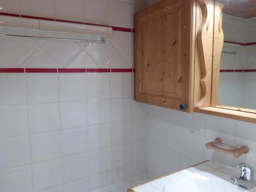 La salle de bains est pourvue d'un lavabo et d'une armoire en bois. dans l'établissement Appartement 3 pièces 6 pers à Méribel Village, pied des pistes, balcon, piscine chauffée - FR-1-411-602, à Les Allues