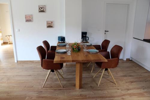 ヴェルニゲローデにあるFerienhaus Sonnenscheinのダイニングルームテーブル(茶色の椅子付)