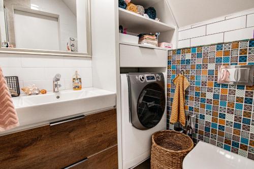 a bathroom with a washing machine and a sink at Rezidence Rokytnice in Rokytnice nad Jizerou