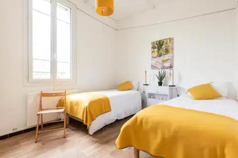 une chambre blanche avec deux lits et une chaise dans l'établissement Mythic Ventoux - Gite Cycliste, à Malaucène