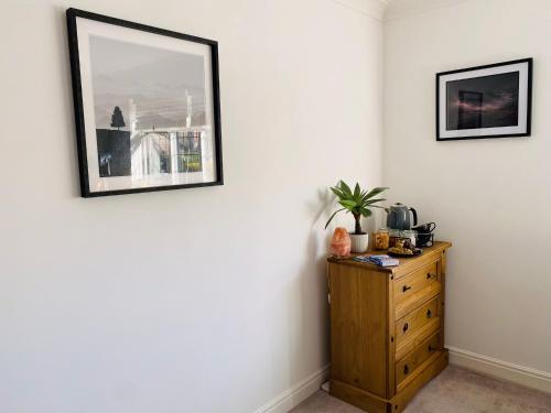 a room with a dresser and a picture on the wall at Driftwood Lodge in Llansantffraid Glan Conwy