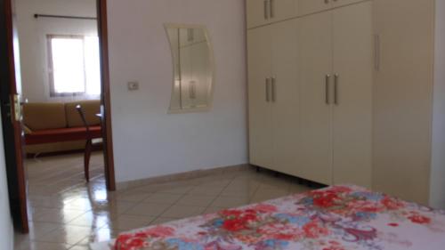 1 dormitorio con armarios blancos y 1 cama. en Bledi's Comfy Apartment in New Blvd / Free Parking, en Tirana